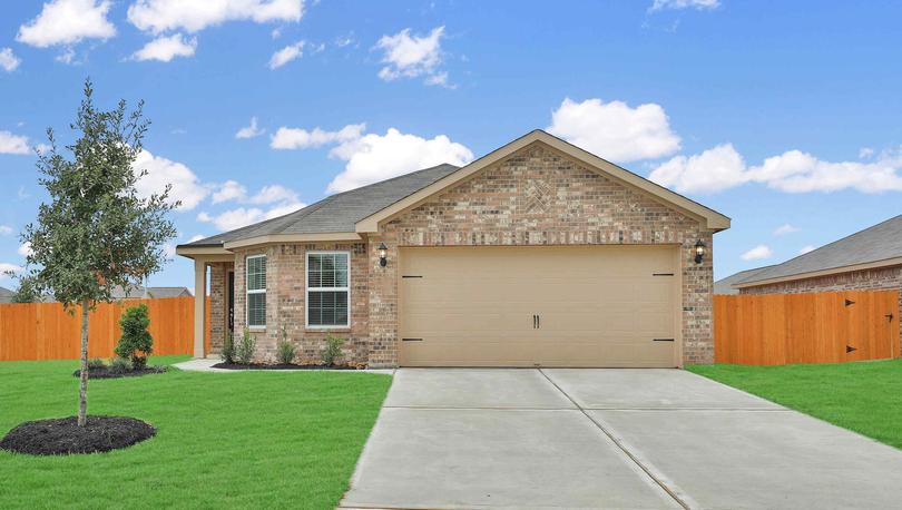 Beautiful brick Pecos by LGI Homes on corner lot with green lawn, wooden fence and landscaping.