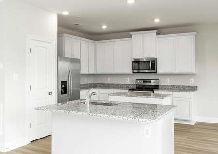 Open kitchen with white cabinets, gray granite counters, stainless appliances, recessed lighting and an island.