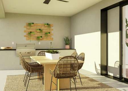 Rendering of the Garza plan's covered
  patio with table and chairs in front of sliding glass doors. The outdoor
  kitchen is visible with grill, wet bar and ample countertop space.