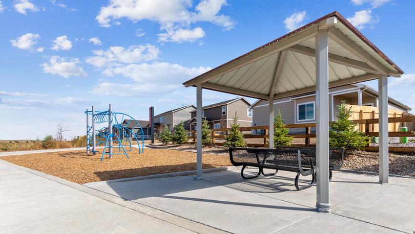 Community park with play structure and shade ramada.