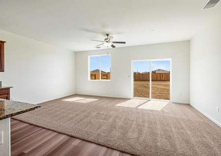 Spacious family room with ceiling fan and carpet