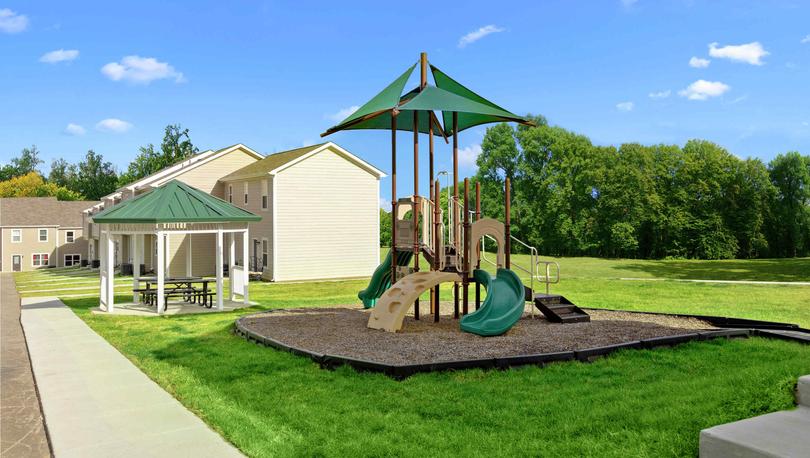 The Cottages of Lake Forest community park features covered pavilion with picnic tables and grassy areas, sun sail covered playground with slide