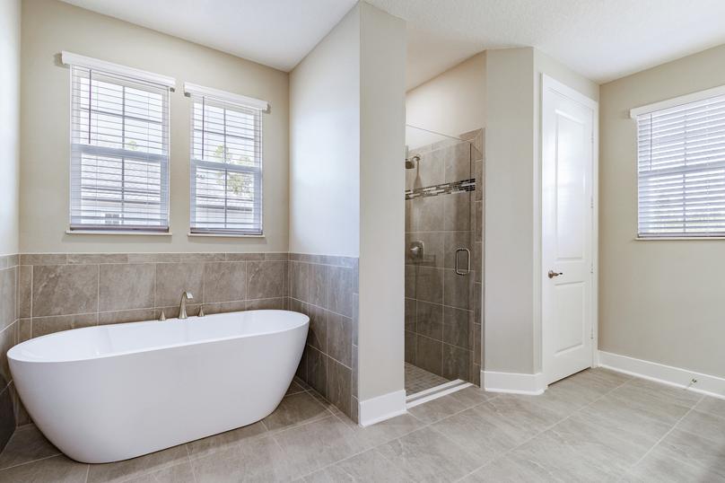 Master bathroom with tile floors, a walk-in shower and a standalone tub.