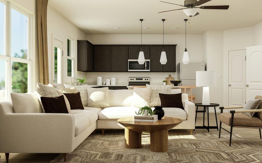 Rendering of the open layout of the
  Jaguar floor plan, featuring living room furniture and a view of the kitchen
  in the background.