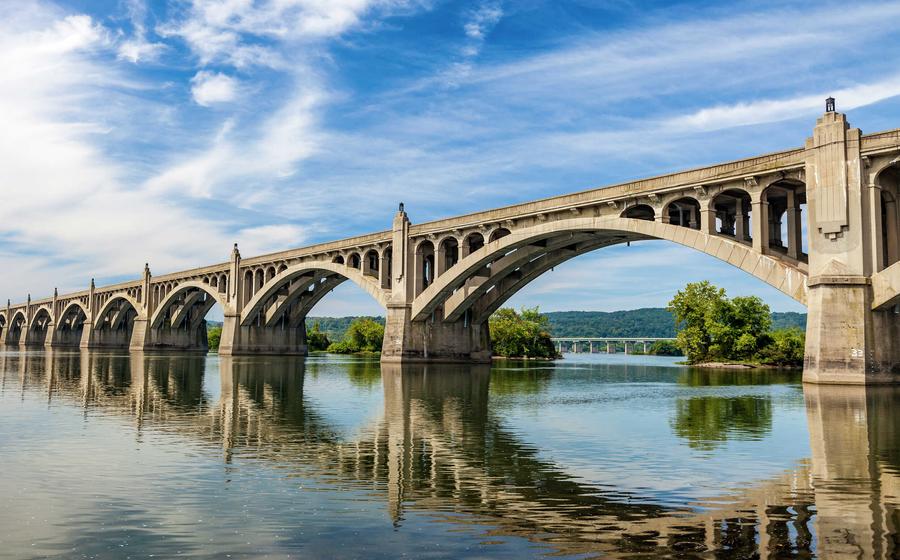 Columbia-Wrightsville Bridge in Pennsylvania with double arched bridge over large waterway with blue skies