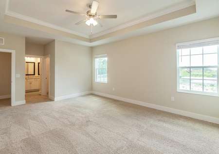 Master bedroom with a vaulted ceiling, two large windows and a spacious full bathroom with a walk-in closet.