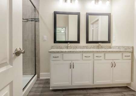 Master bathroom featuring double sinks and a spacious shower.