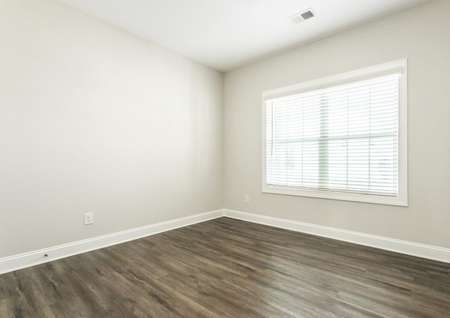 Flex room with vinyl flooring and a large window with blinds.
