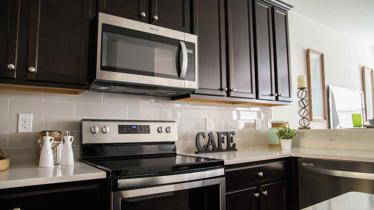 The kitchen in the Sea Forest Beach Club with granite countertops, dark brown cabinets and new appliances