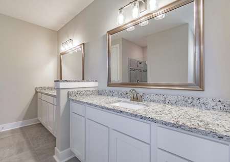 Master bath with granite countertops, tons of storage and two framed mirrors.