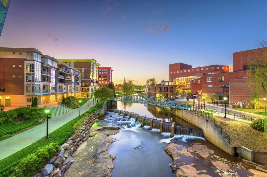 Greenville, South Carolina, USA downtown cityscape on the Reedy River at dusk.