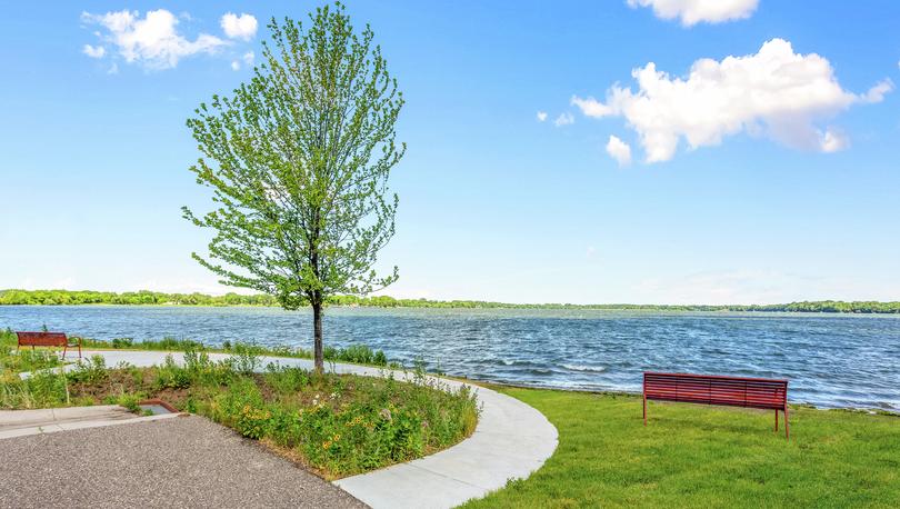 Lions park with lake views and a park bench.