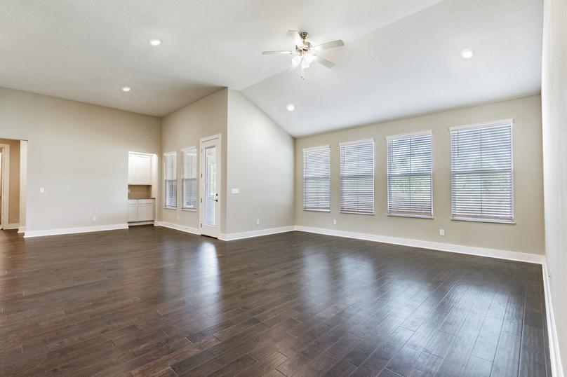 Living room with four large windows and wood floorings. 