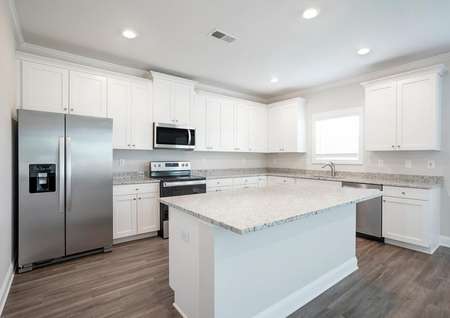 Kitchen with granite island and stainless steel appliances.