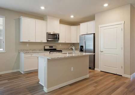 The kitchen comes complete with stainless steel appliances and white cabinetry.