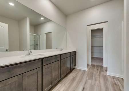 The master bath has a dual-sink vanity and brown cabinetry.
