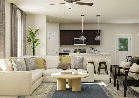 Rendering of the Keaton's living room
  furnished with large cream sectional sofa, round coffee table and two dark
  grey armchairs. The kitchen and dining table are visible in the background.