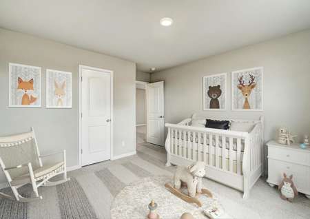 Staged nursery with a rocking chair and a white crib.