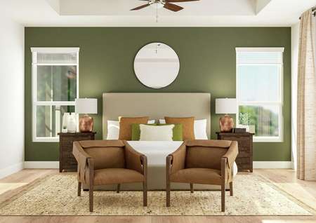 Rendering of the master bedroom focusing
  on two leather accent chairs sitting at the foot of a large bed. Two copper
  table lamps sit on nightstands in front of a green accent wall that features
  two large windows.