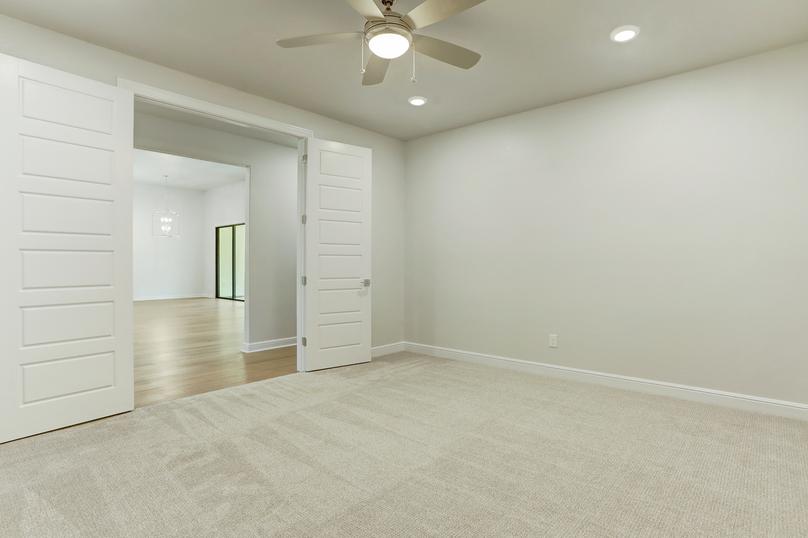 The Mantle features an incredible flex room with brown carpet, a ceiling fan and white walls.