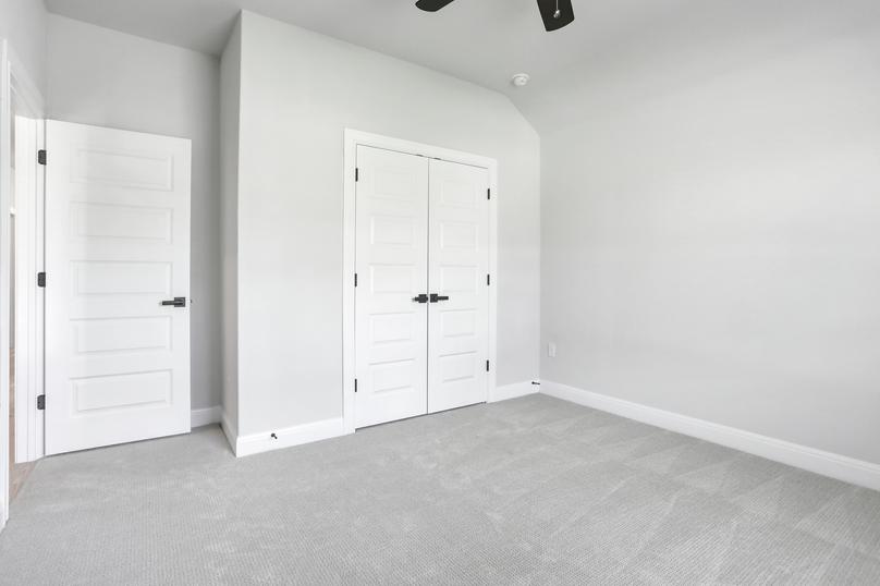 Guest bedroom with a ceiling fan, a closet with double doors, and light gray carpet.