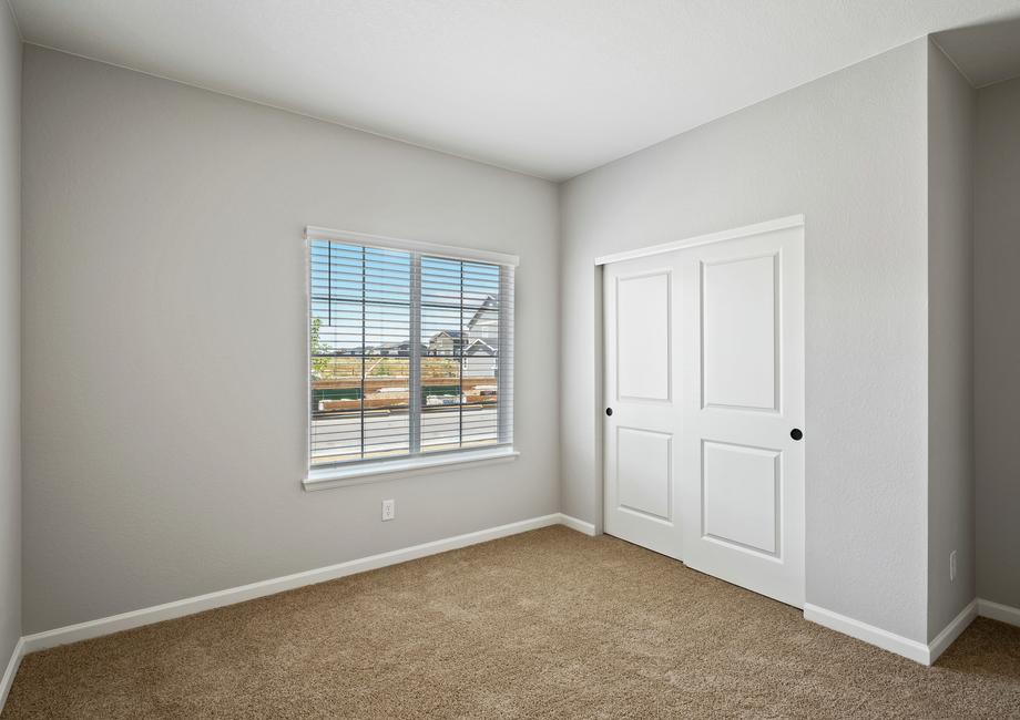 Guest bedroom with a closet that has sliding doors.