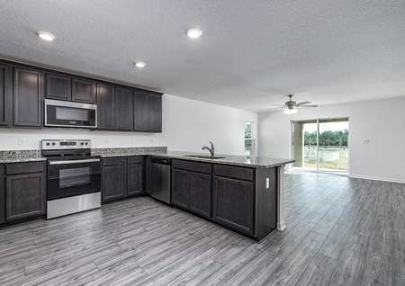 Chef-ready kitchen overlooking entertainment space with large windows.