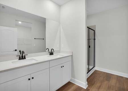 The master bath has a double sink vanity and walk in shower