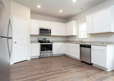 Chef-ready kitchen with white cabinets and stainless steel appliances 