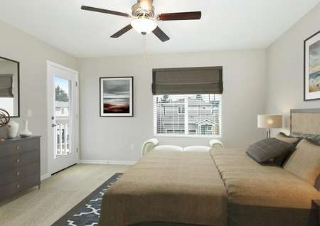 Decorated master bedroom with a bed, dresser with mirror, end tables, ceiling fan, double window and glass door to balcony.