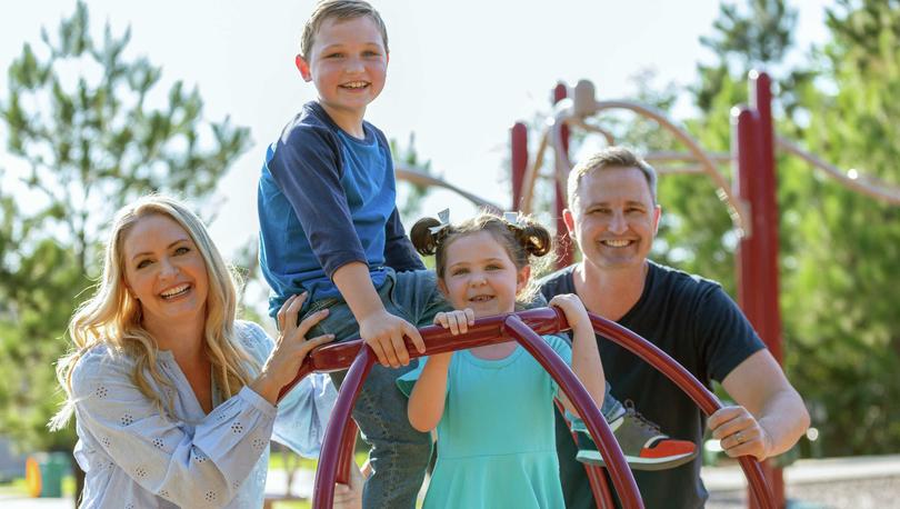 Family posing on the community playground. 