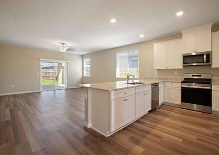 The kitchen has sprawling countertops, white cabinetry and stainless steel appliances.