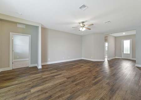 The living room is spacious with beautiful hardwood floors and a celling fan