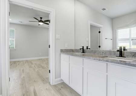 Designer master bathroom with matte black fixtures, white cabinetry, and granite countertops.