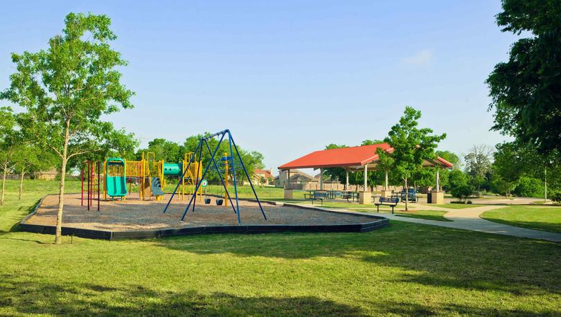Bunton Creek new home community park with green grass, trails, and play equipment for kids 