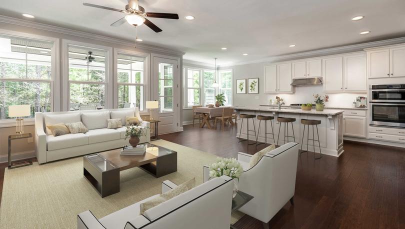 Living room and kitchen with wood floors and stainless steel appliances.