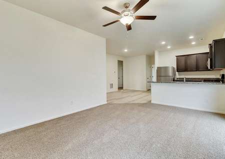 Family room with carpet, adjacent to the kitchen, perfect for family game nights.