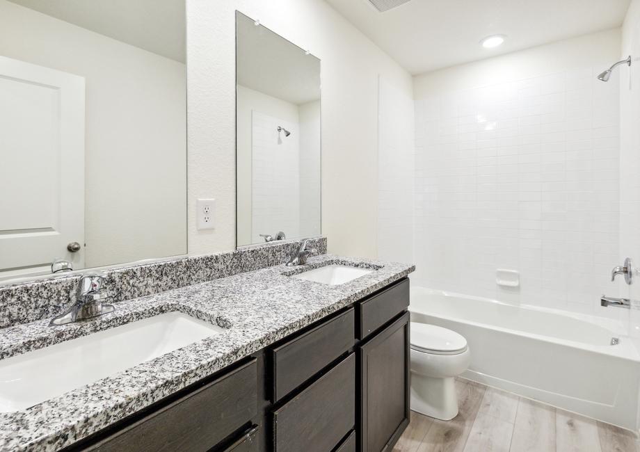 Secondary bathroom with a double-sink vanity and a dual shower and tub.