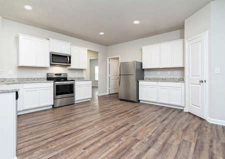 Chef-ready kitchen with stainless appliances, white cabinets, and wood-style flooring.