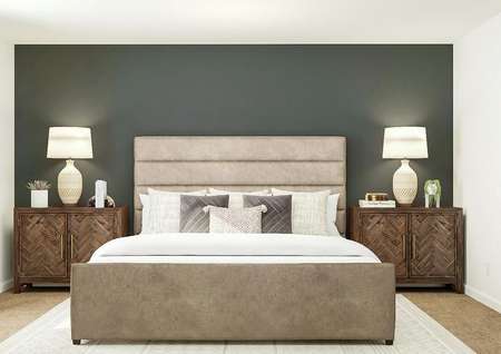 Rendering of owners bedroom with large
  bed, dark gray accent wall and dual side tables.