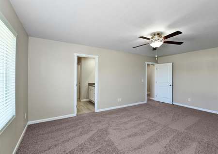 Master bedroom with ceiling fan and carpet