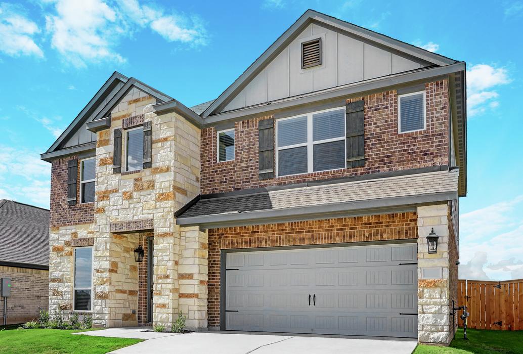 Exterior of the Sterling with beautiful landscaping, coach lights, and a two-car garage.