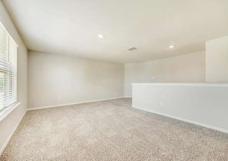 The upstairs game room has light walls and carpet.