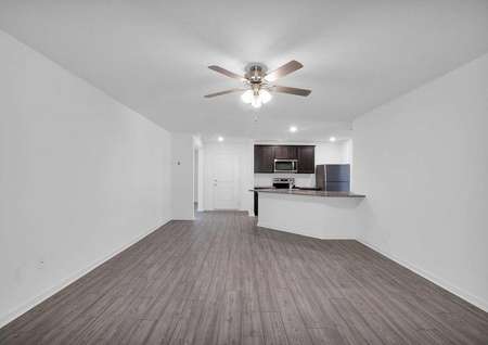 A spacious family room with luxury vinyl plank flooring that leads to a chef-ready kitchen. 