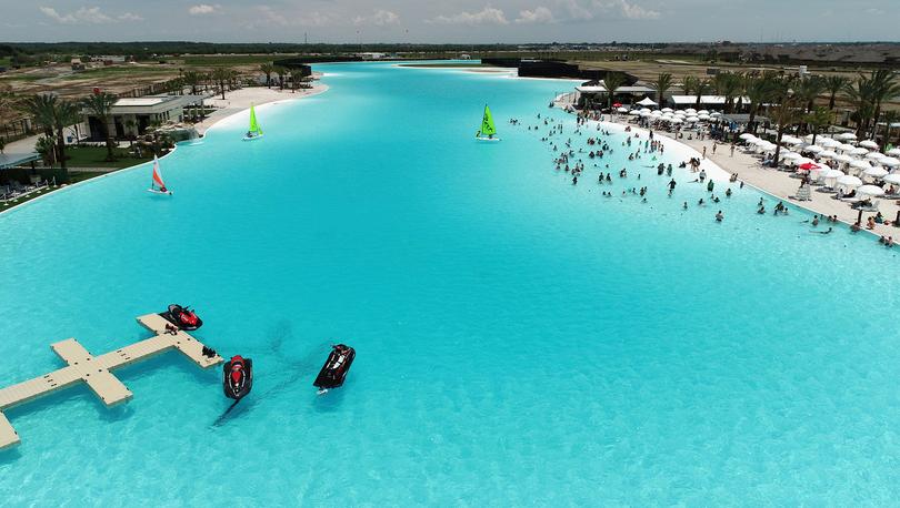 Wide shot of Lago Mar lagoon with sail boats and swimmers