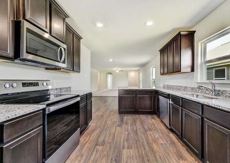 Medina kitchen with granite countertops, hardwood floors, and custom brown cabinets