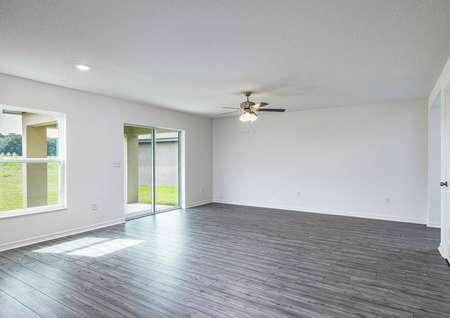 The family room has vinyl plank floors and leads to a covered back patio. 