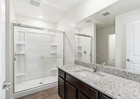 Master bathroom with a large walk-in shower, granite countertops, and espresso cabinets. 