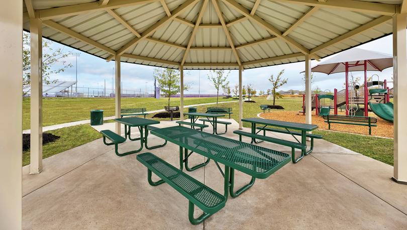 Covered picnic area with green picnic tables.