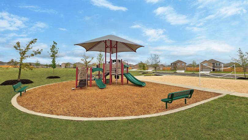 The community park with a playground and sand volleyball court.